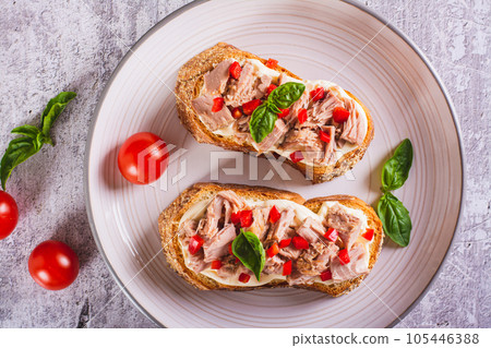 Close up of sandwiches with canned tuna, pepper and basil on cream cheese on a plate top view 105446388