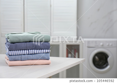 Fresh laundry on white wooden table in bathroom. Space for text Fresh laundry on white wooden table in bathroom. Space for text 105446592
