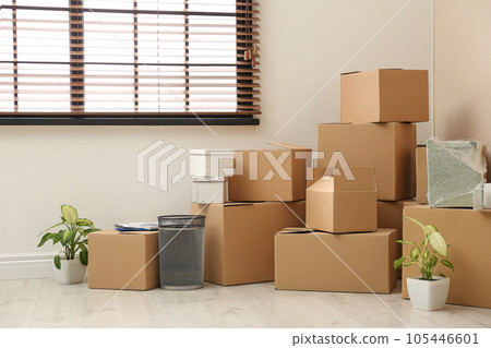Moving boxes and stuff near window in room 105446601