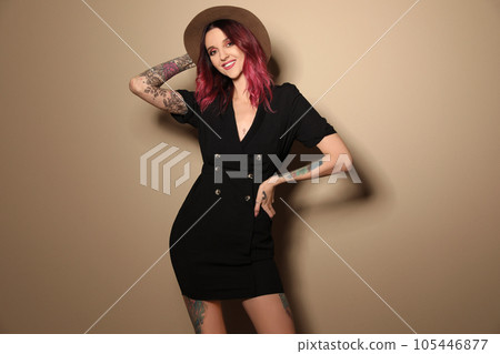 Beautiful woman with tattoos on body against beige background Beautiful woman with tattoos on body against beige background 105446877