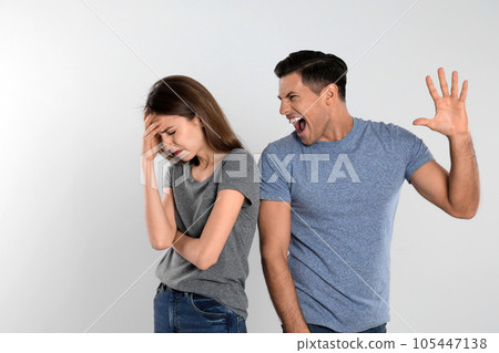 Man shouting at his girlfriend on light background. Relationship problems Man shouting at his girlfriend on light background. Relationship problems 105447138