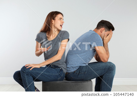 Woman shouting at her boyfriend on light background. Relationship problems Woman shouting at her boyfriend on light background. Relationship problems 105447140
