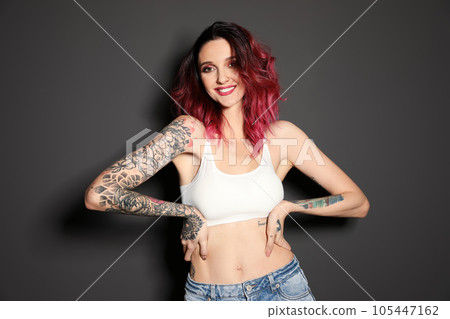 Beautiful woman with tattoos on body against black background 105447162