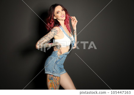 Beautiful woman with tattoos on body against black background. Space for text 105447163