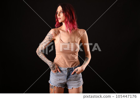 Beautiful woman with tattoos on body against black background 105447176