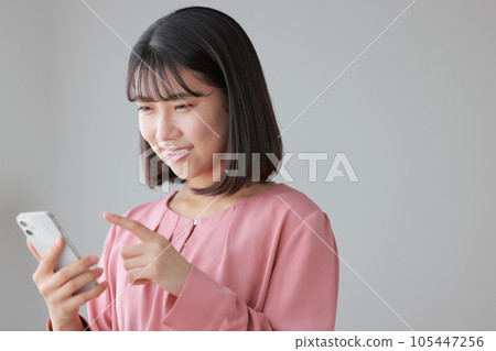 一位穿著休閒服的女士正在操作智能手機_2 一位穿著休閒服的女士正在操作智能手機_2 105447256