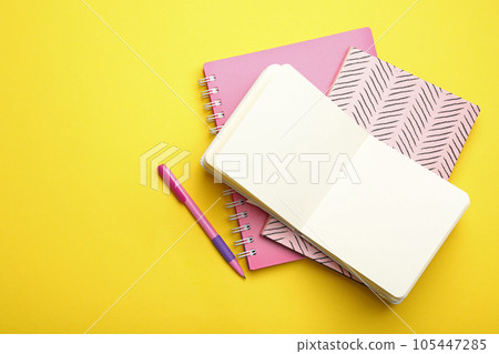 Stylish notebooks and pen on yellow background, flat lay. Space for text Stylish notebooks and pen on yellow background, flat lay. Space for text 105447285
