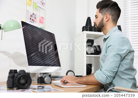 Professional photographer working at table in office 105447339