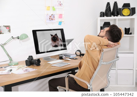 Professional photographer resting at workplace in office 105447342