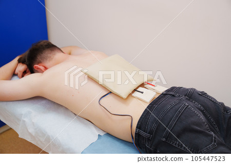patient with an electrotherapy on the back, electrical stimulation patient with an electrotherapy on the back, electrical stimulation 105447523