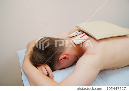 patient with an electrotherapy on the back, electrical stimulation patient with an electrotherapy on the back, electrical stimulation 105447527