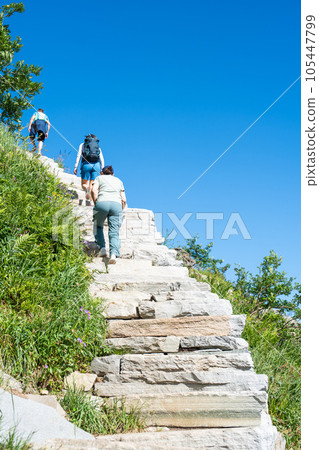 Tourists climb the stairs to the top of the mountain. Norway hiking path in mountains. Lofoten, Reinebringen 105447799