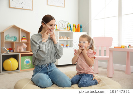 Speech therapist working with little girl in office 105447851