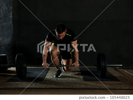 Strong man lifting barbell in modern gym Strong man lifting barbell in modern gym 105448025