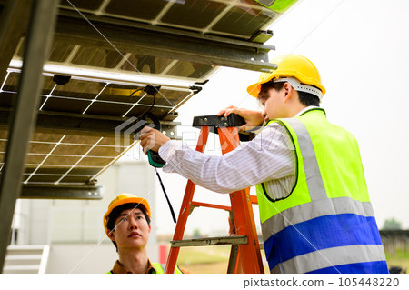 Maintenance engineer checking solar panels on solar cell farm 105448220
