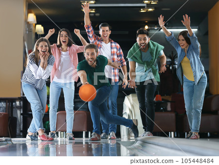Young man throwing ball and spending time with friends in bowling club Young man throwing ball and spending time with friends in bowling club 105448484