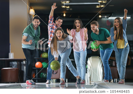 Young woman throwing ball and spending time with friends in bowling club Young woman throwing ball and spending time with friends in bowling club 105448485