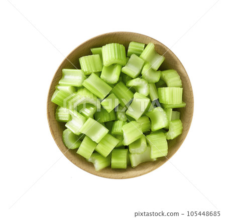Chopped fresh celery in a wooden bowl isolated on white background, top view. Chopped fresh celery in a wooden bowl isolated on white background, top view. 105448685