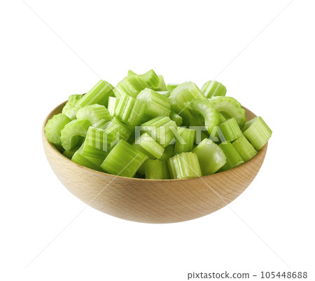 Pieces of celery in a wooden bowl isolated on white background. Pieces of celery in a wooden bowl isolated on white background. 105448688