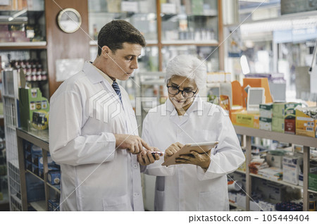 skilled pharmacist is consulting, analyzing the use of drugs to recommend and supervise patients according to prescriptions in modern pharmacies. 105449404