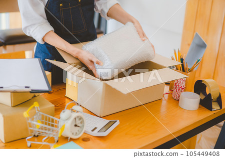 Online small business owners are packing their ordered products into the boxes for their customers based on the concept of online shopping - online shopping. Online small business owners are packing their ordered products into the boxes for their customers based on the concept of online shopping - online shopping. 105449408