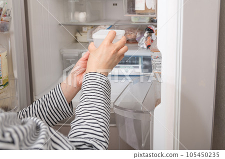 [一位家庭主婦從冰箱裡拿出一個水龍頭] 105450235