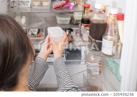 [A housewife taking out a tapper from the refrigerator] 105450236