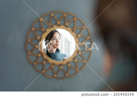 Photo of a woman looking in the mirror Photo of a woman looking in the mirror 105450334