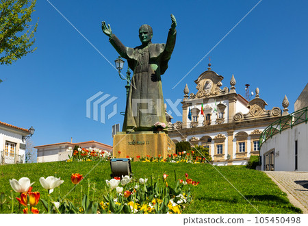 Statue of John Paul II against backdrop of town hall in Mirandela, Portugal 105450498