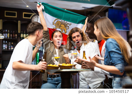 Excited sports fans celebrating victory of favorite Iranian team in bar Excited sports fans celebrating victory of favorite Iranian team in bar 105450517