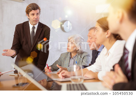 Entrepreneur explaining business strategy to partners in office 105450530