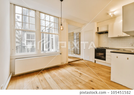an empty kitchen with wood floors and white appliances on the stove top in this photo is taken from the living room an empty kitchen with wood floors and white appliances on the stove top in this photo is taken from the living room 105451582