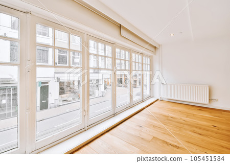 an empty room with wood flooring and large windows looking out onto the street in london, uk stock photo 105451584