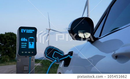 Electric car recharging energy from charging station in wind turbine farm.Peruse Electric car recharging energy from charging station in wind turbine farm.Peruse 105451662
