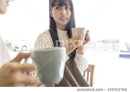 A young female college student having tea at a cafe A young female college student having tea at a cafe 105452768