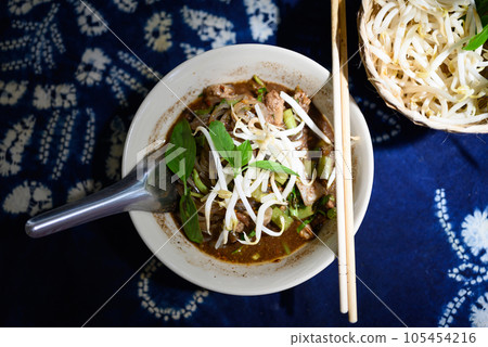 Rice noodles soup with pork and vegetables, Thai boat noodles style, Table top view Rice noodles soup with pork and vegetables, Thai boat noodles style, Table top view 105454216