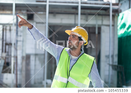 Man engineer happy cheerful wear uniform holding walkie talkie standing at construction site. Man engineer happy cheerful wear uniform holding walkie talkie standing at construction site. 105455339