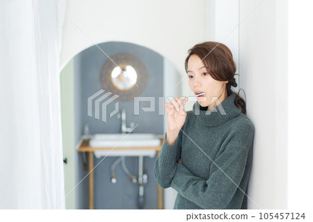 Photo of a woman brushing her teeth Photo of a woman brushing her teeth 105457124