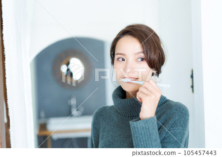 Photo of a woman brushing her teeth Photo of a woman brushing her teeth 105457443