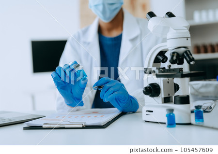 Modern medical research laboratory. African female scientist working with micro pipettes analyzing biochemical samples, advanced science chemical laboratory for medicine. . 105457609