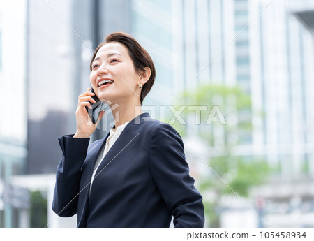 Business woman using smartphone in office district Business woman using smartphone in office district 105458934