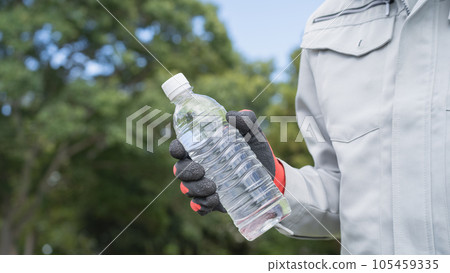 A man in work clothes and a plastic bottle of water | Construction industry heatstroke prevention image A man in work clothes and a plastic bottle of water | Construction industry heatstroke prevention image 105459335