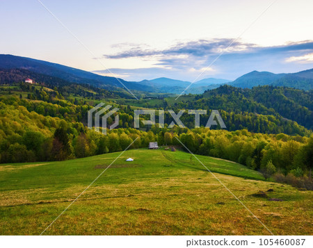 natural beauty of the rural landscape. grassy rolling hills in evening light. mountain ridge in the distance natural beauty of the rural landscape. grassy rolling hills in evening light. mountain ridge in the distance 105460087