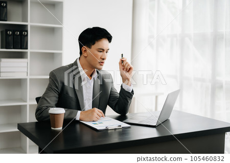 Young business man working at office with laptop, tablet and taking notes on the paper.. 105460832