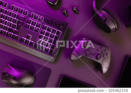 Purple lit keyboard amidst various devices Purple lit keyboard amidst various devices 105462159