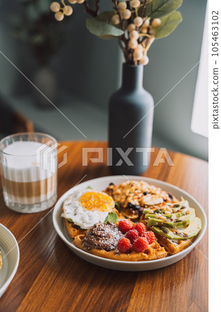 Waffles with seafood and avocado on a white plate with coffee Waffles with seafood and avocado on a white plate with coffee 105463102