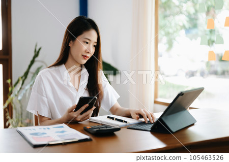 Asian woman working in the office with working notepad, tablet and laptop documents 105463526