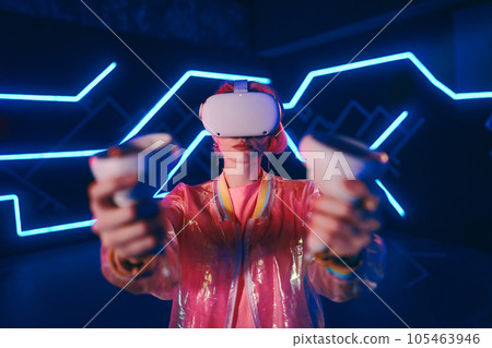 A young woman plays virtual games. Neon room for vr games. A young woman plays virtual games. Neon room for vr games. 105463946