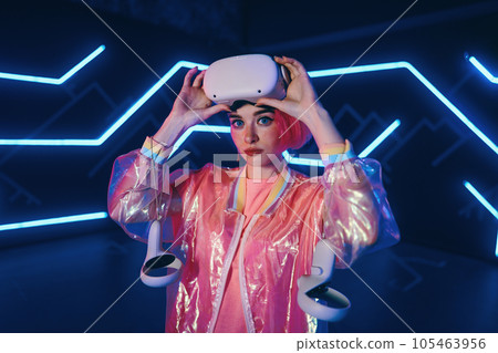 A young woman plays virtual games. Neon room for vr games. A young woman plays virtual games. Neon room for vr games. 105463956