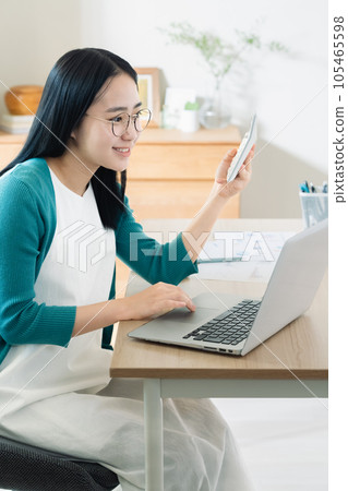 用計算機和計算器計算的年輕女子 105465598